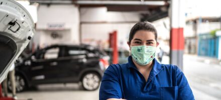 Women with mask on in car garage